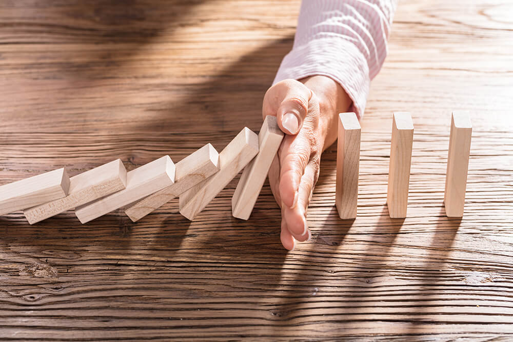 Hand preventing dominos falling image